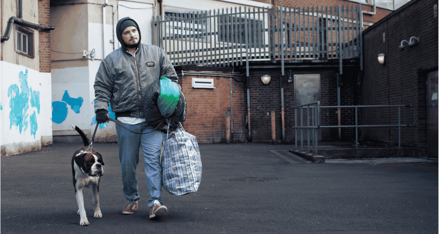 a man carrying a bag is walking his dog