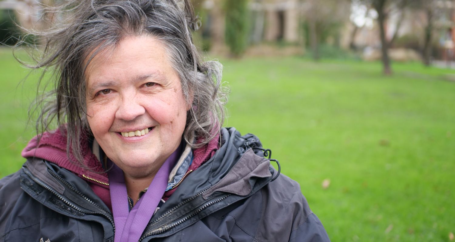 Image of a woman in the park smiling.